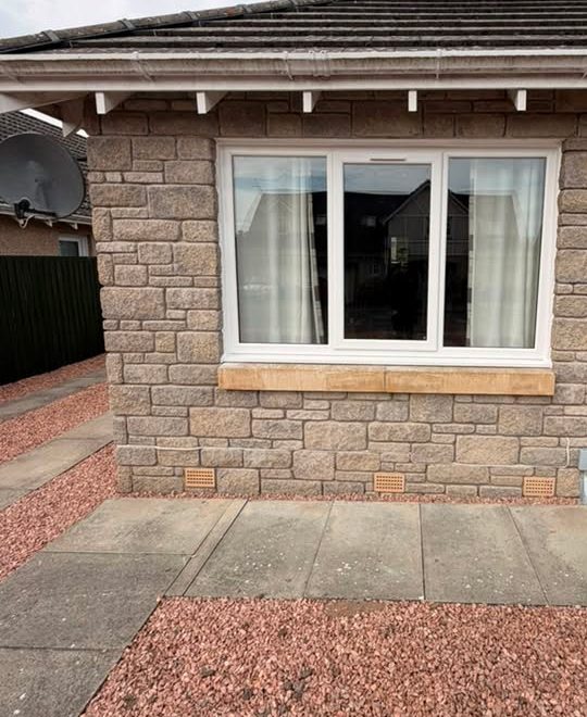 New white uPVC window on the front of a stone-faced bungalow in Arbroath, replacing a rotten wooden frame