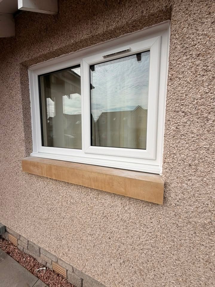 Close-up of a new white uPVC window with a stone sill and a trickle vent, fitted in Arbroath